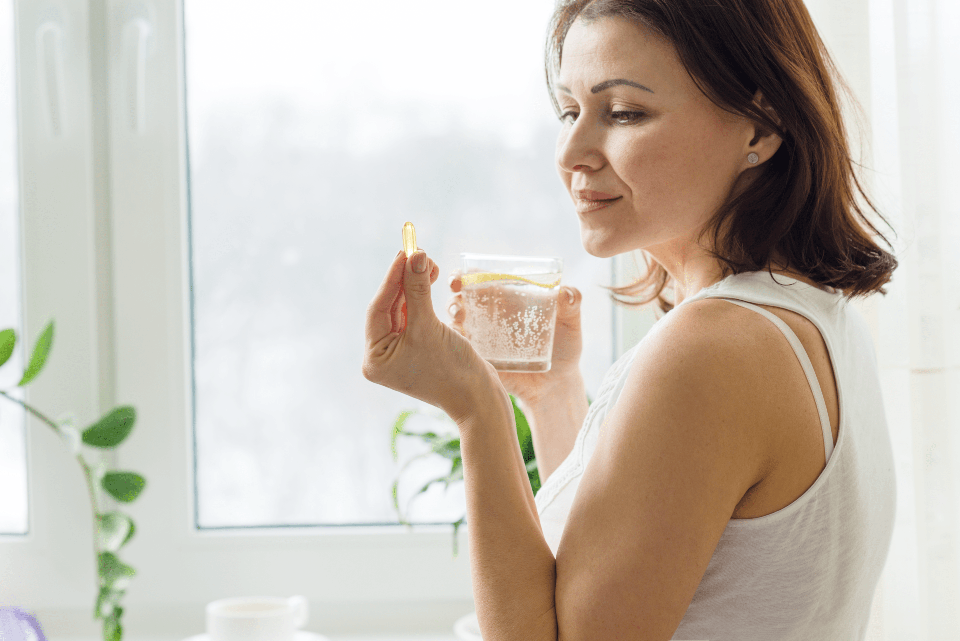 woman-takes-pill-with-omega-3-and-holding-a-glass-2022-01-20-20-07-54-utc 1